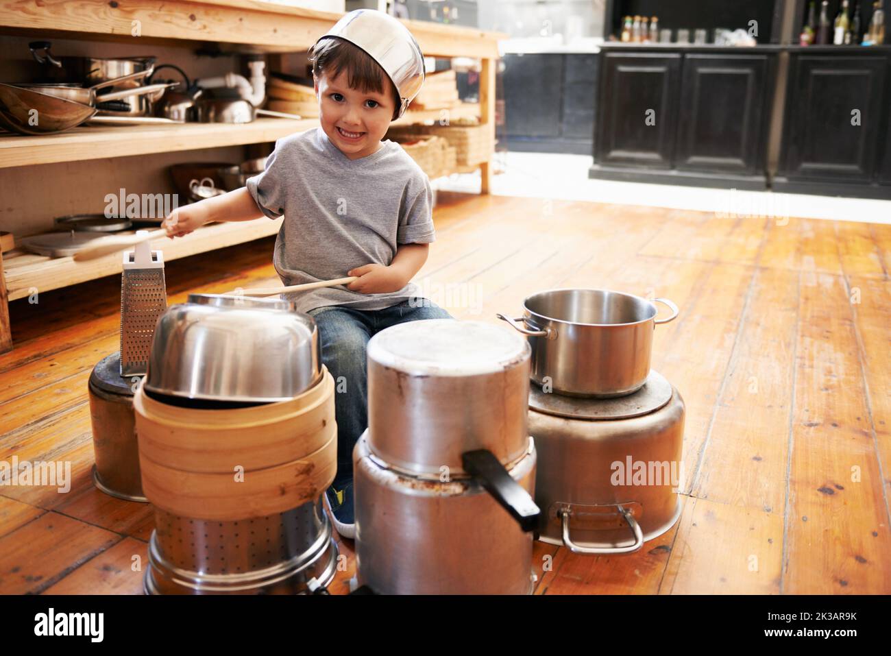Never give up on childhood dreams. A little boy playing drums on pots
