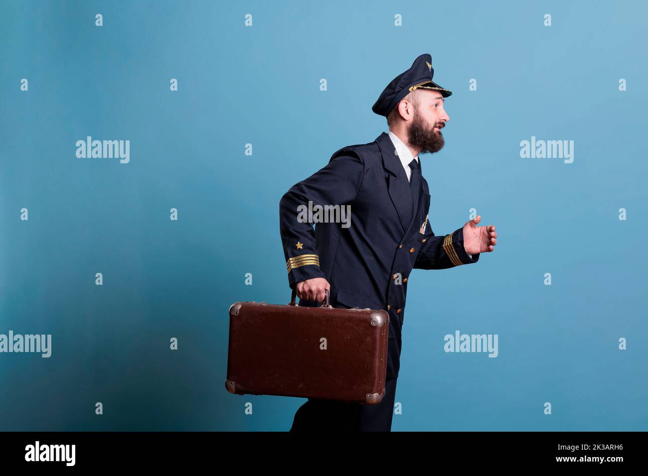 Airplane captain in professional airline uniform running late, carrying