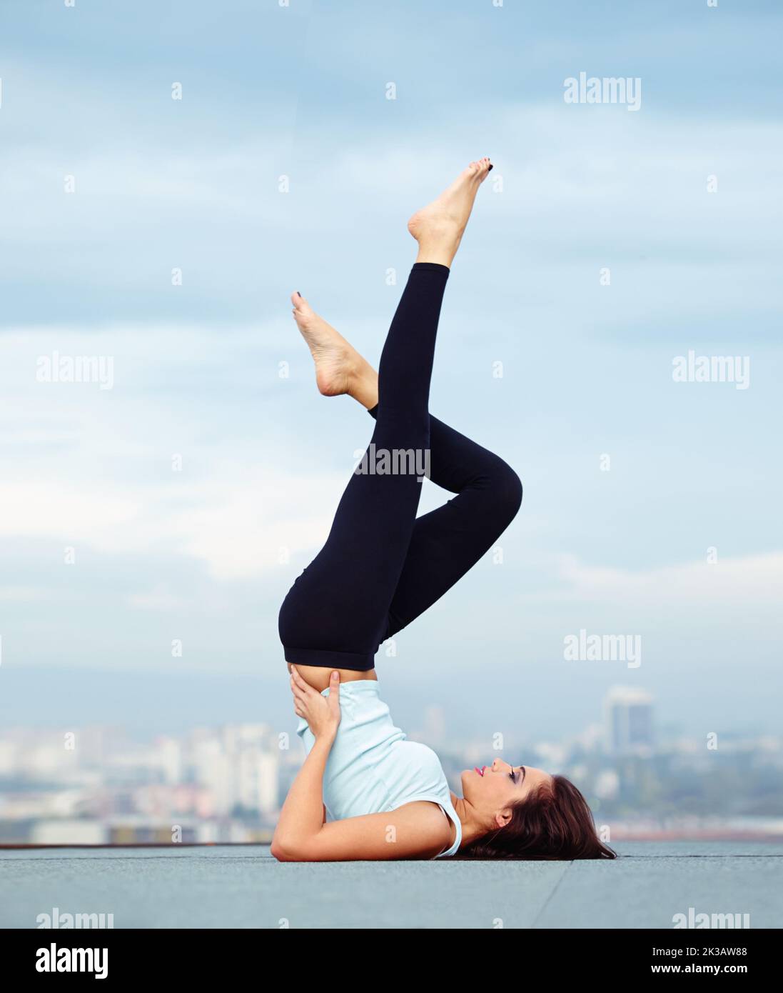 Rooftop exercise. An attractive young woman exercising outdoors. Stock Photo