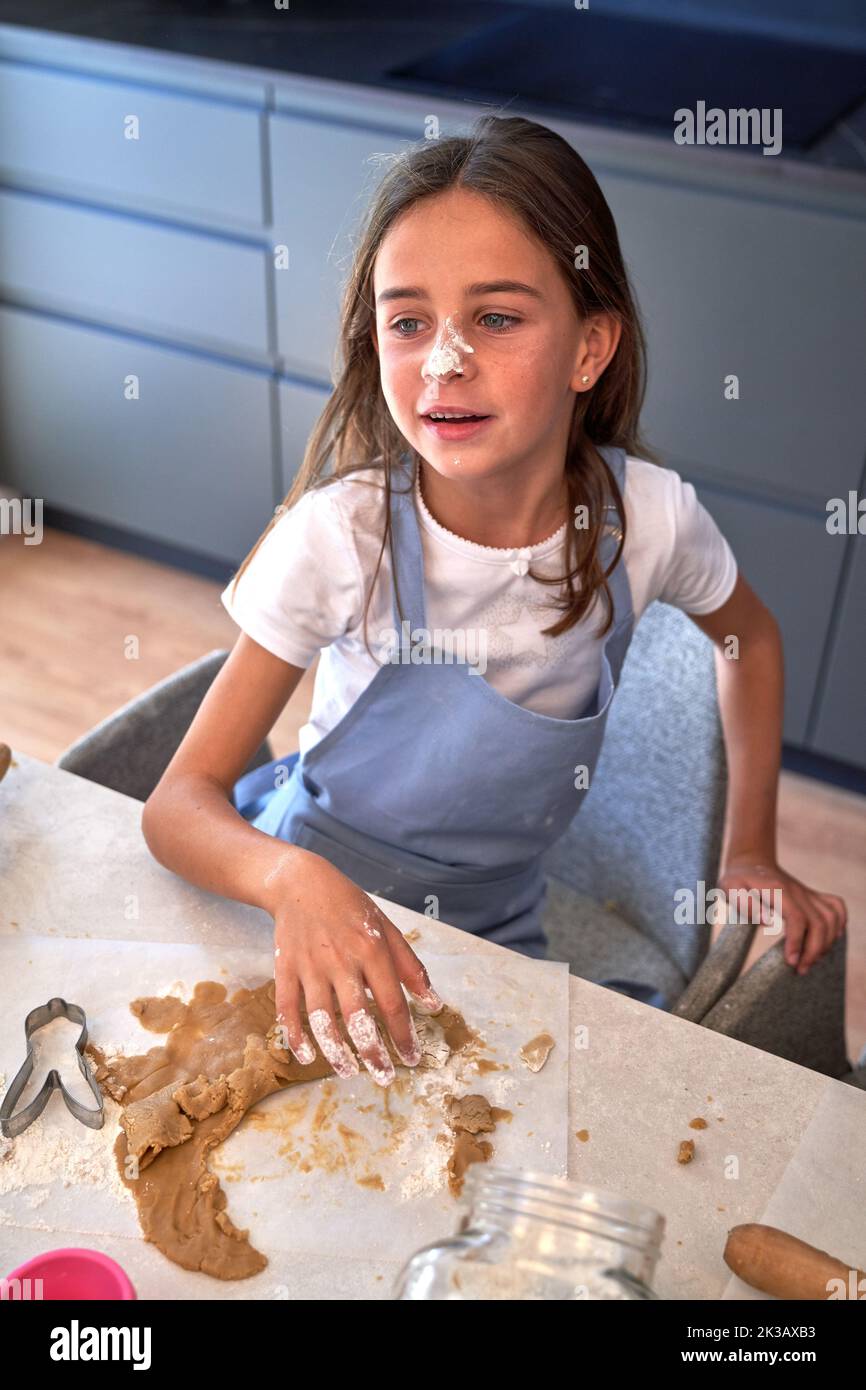 Child in blue apron molding dough in kitchen Stock Photo Alamy