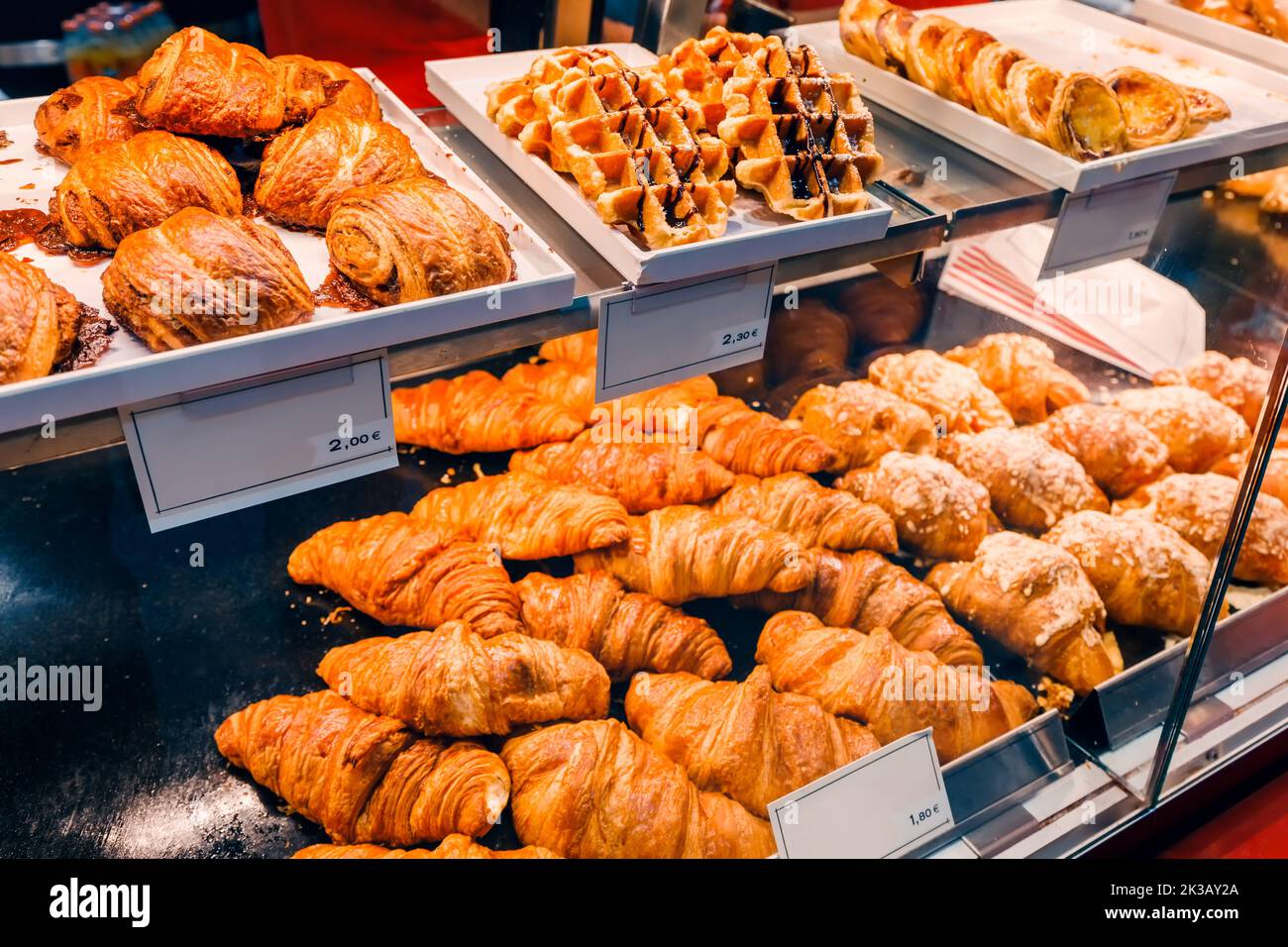 Croissants and other rolls and pastries are sold in the shop window. Sweet tooth and confectionery concept Stock Photo
