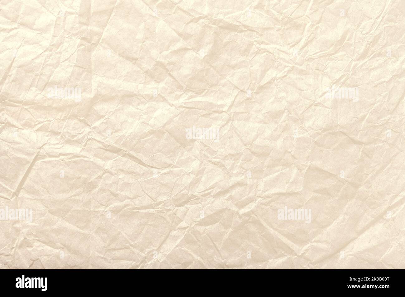 Texture of crumpled light beige wrapping paper background, macro. Pearl