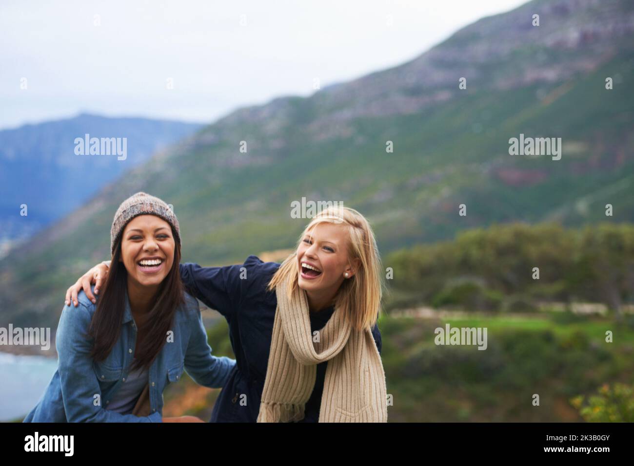 Taking in the mountain views. Two young women laughing outside Stock ...