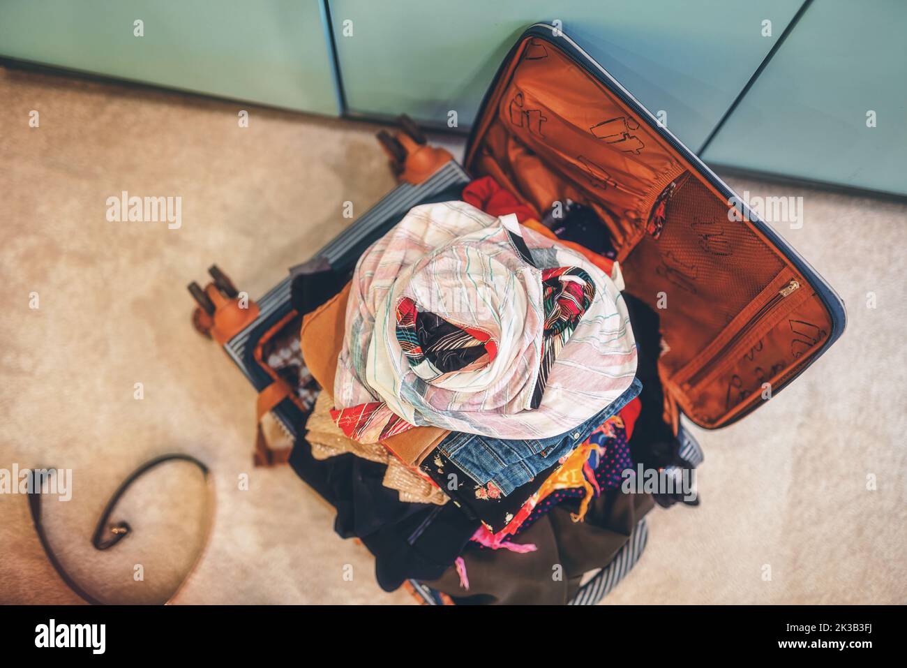 Open suitcase full of clothes in room Stock Photo Alamy