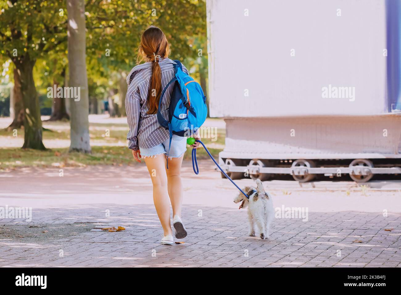 A girl walks her dog out in the city park. Frienship and pets lifestyle Stock Photo
