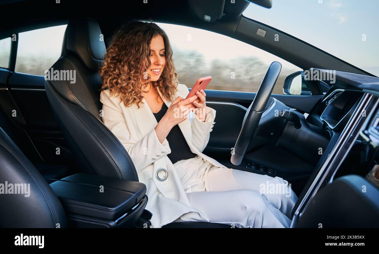 Millennial business woman using mobile application for tracking location GPS during car transportation, successful female in vehicle searching information on website for drivers using 4g wireless Stock Photo