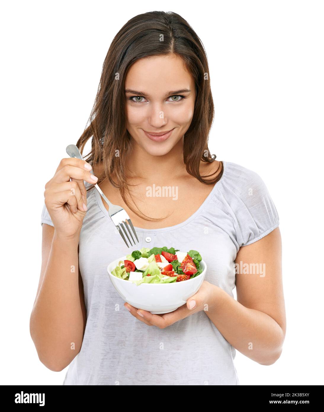 Enjoying a healthy snack. Portrait of a young woman enjoying a fresh salad. Stock Photo