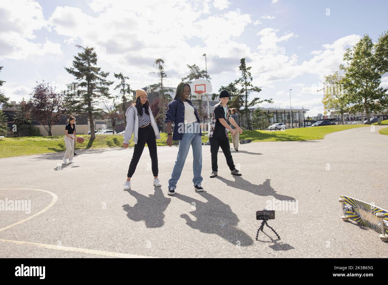 Multiethnic teens making dance video in basketball court Stock Photo Multiethnic teens making dance video in basketball court Stock Photo