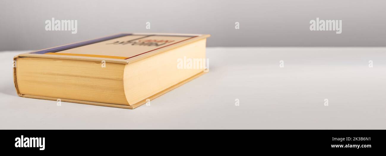 Banner with hardback book at table. Novel, encyclopedia. Classic literature. Reading leisure, education, wisdom concept. Copy space. High quality phot Stock Photo