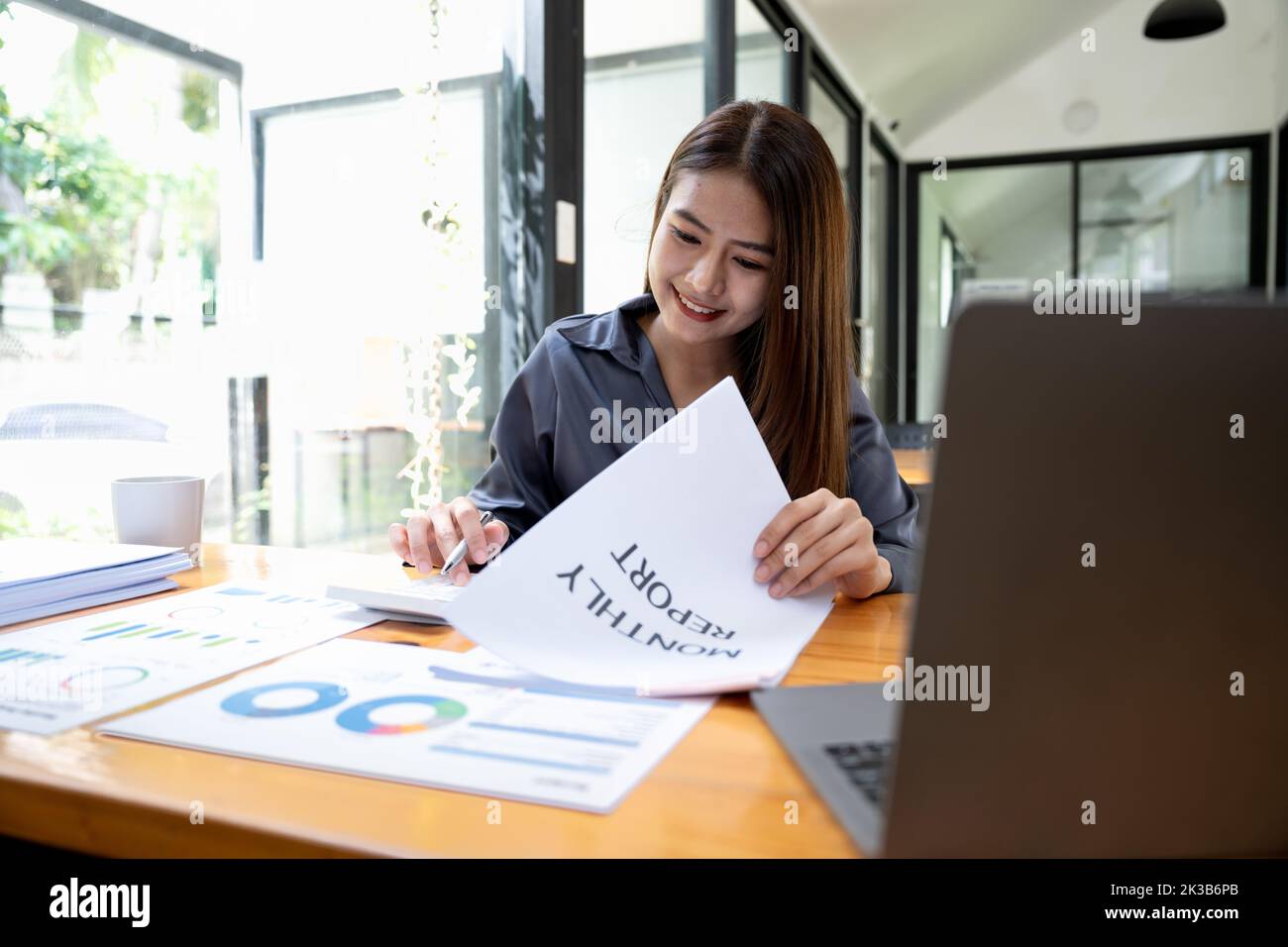 Business asian woman accountant or financial expert analyze business report graph and finance chart at corporate office. Concept of finance economy Stock Photo