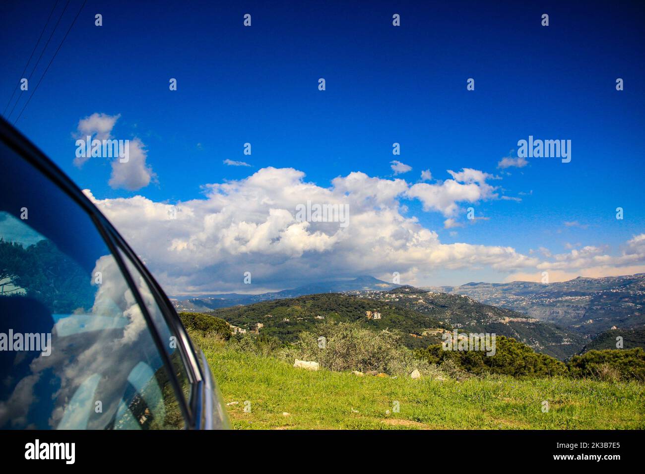 The car glass reflecting the landscape of Kadisha Valley with blue sky