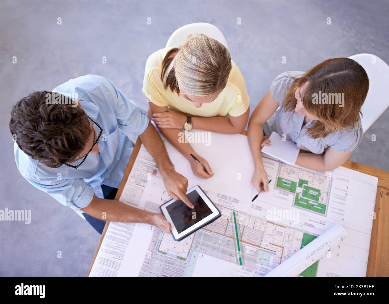 We can find inspiration online. Top view of a group of young architects using a digital tablet to do research together. Stock Photo