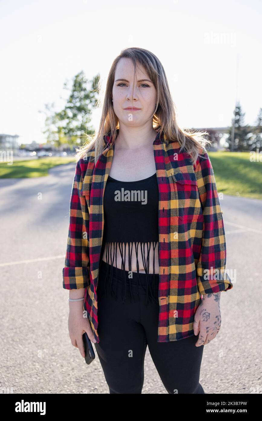 Portrait of woman in checked shirt in park Stock Photo
