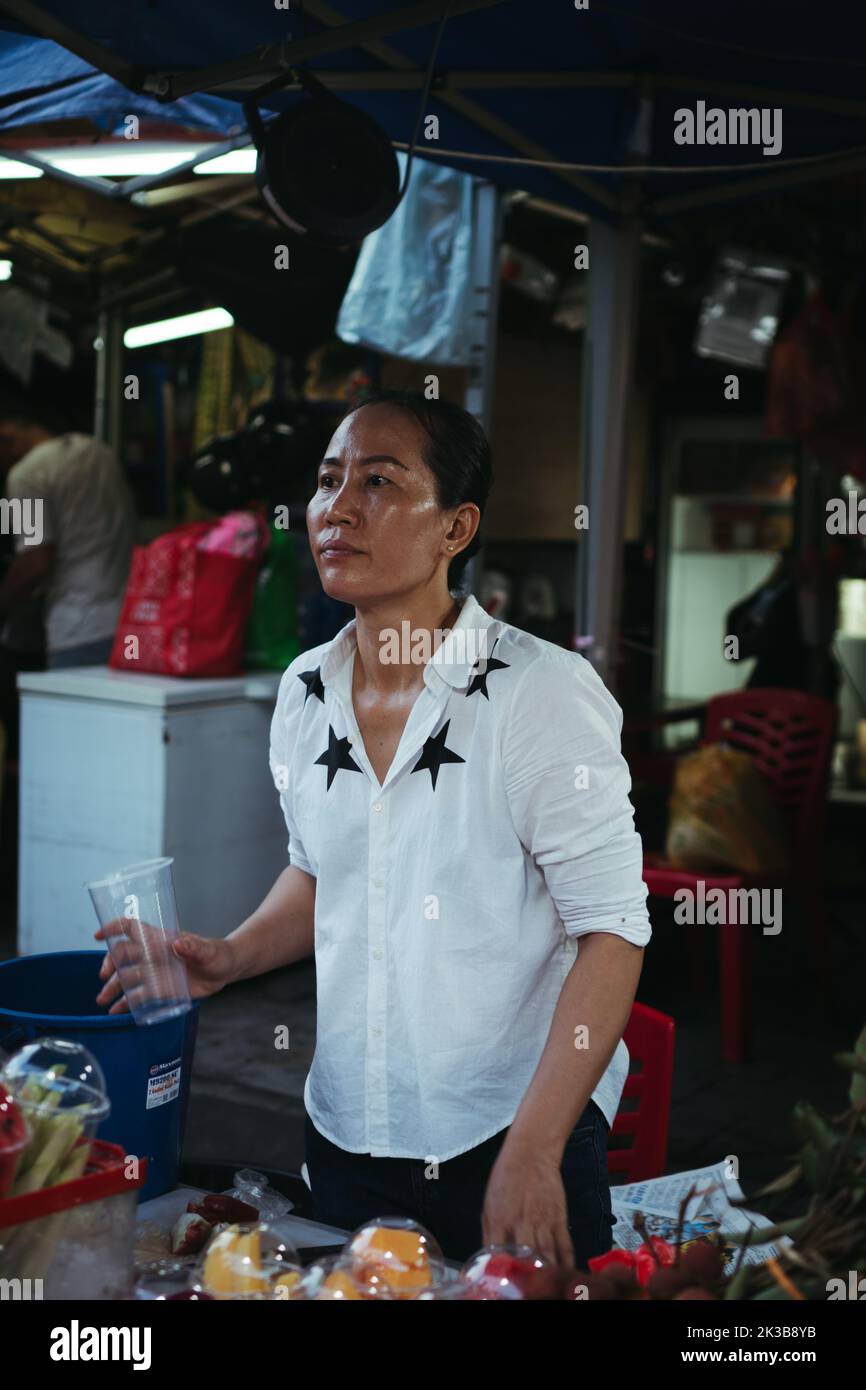 A feman street food vendor in Petaling Street, Kuala Lumpur, Malaysia Stock Photo