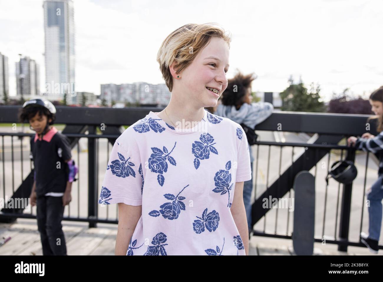 Portrait of girl in flowery tshirt on bridge over skatepark Stock Photo