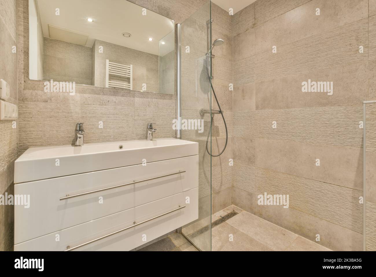 Glass partition between shower tap and wall hung toilet in modern