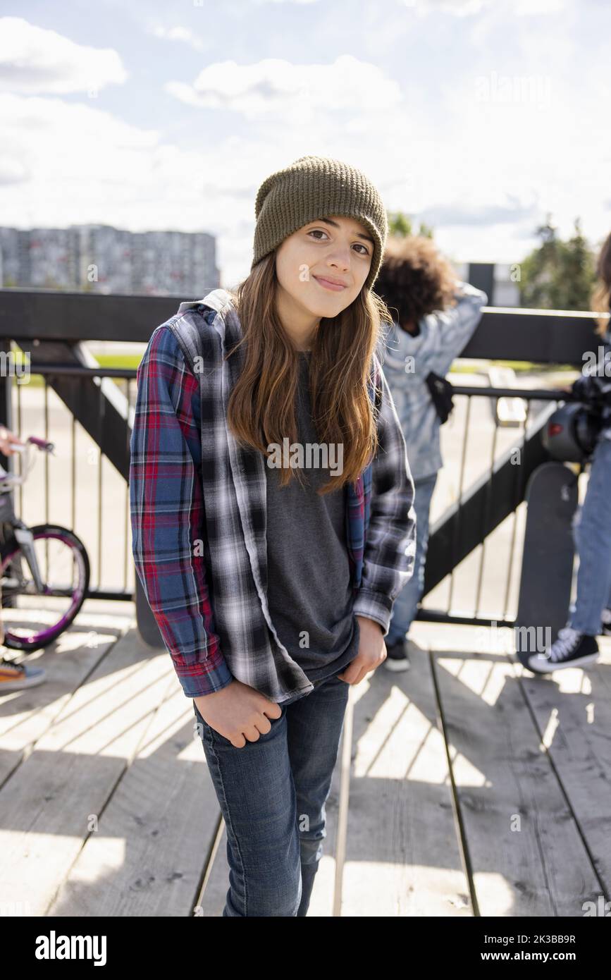 Portrait of girl in checked shirt on bridge over skatepark Stock Photo