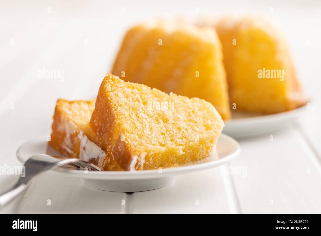 Sweet sponge cake. Bundt cake on plate on the white table. Stock Photo