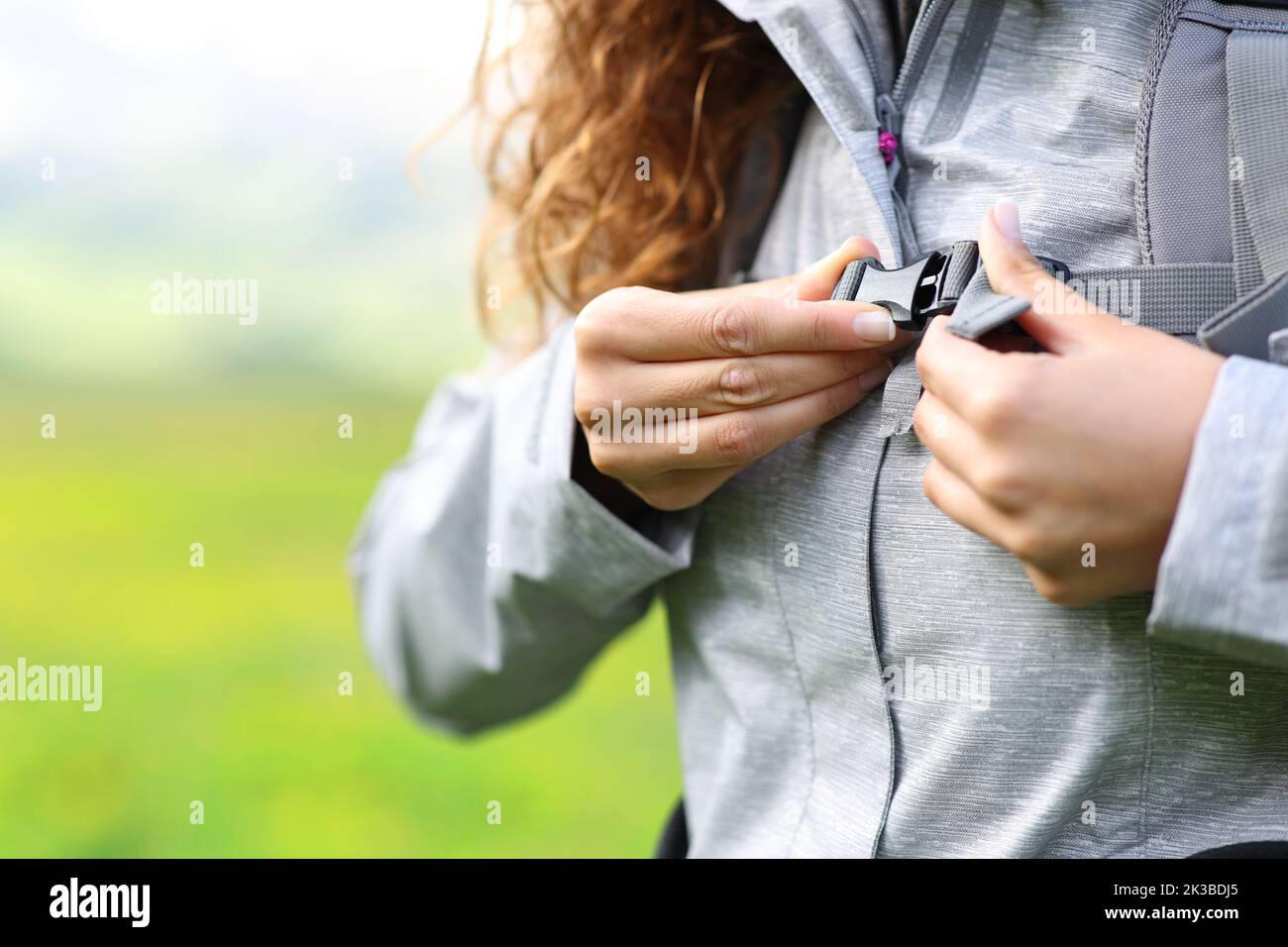 Close up of a hiker hands fastening backpack on chest Stock Photo