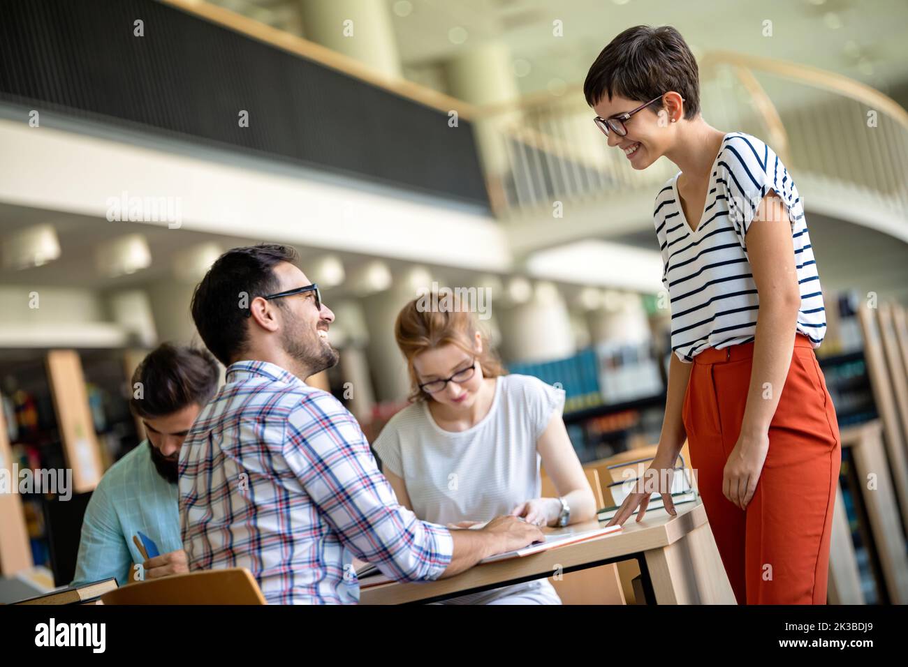 Happy university students studying with books in library. Group of multiracial people in college Stock Photo