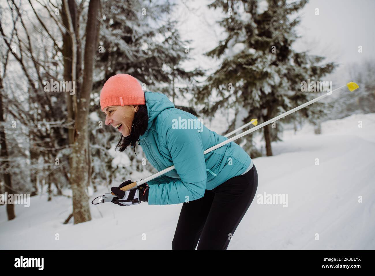 Senior woman skiing in the middle of snowy forest. Stock Photo