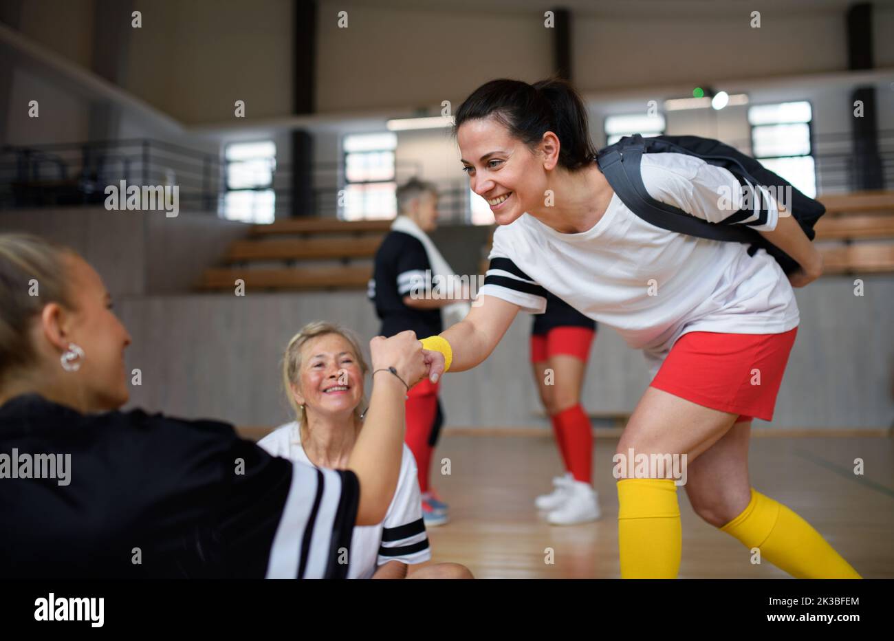 Multigenerational teammates greeting each other in gym. Stock Photo