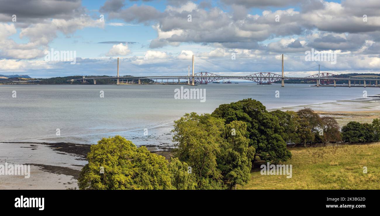 View along the Forth River near Edinburgh in Scotland, with the three Forth bridges in the distance. Stock Photo