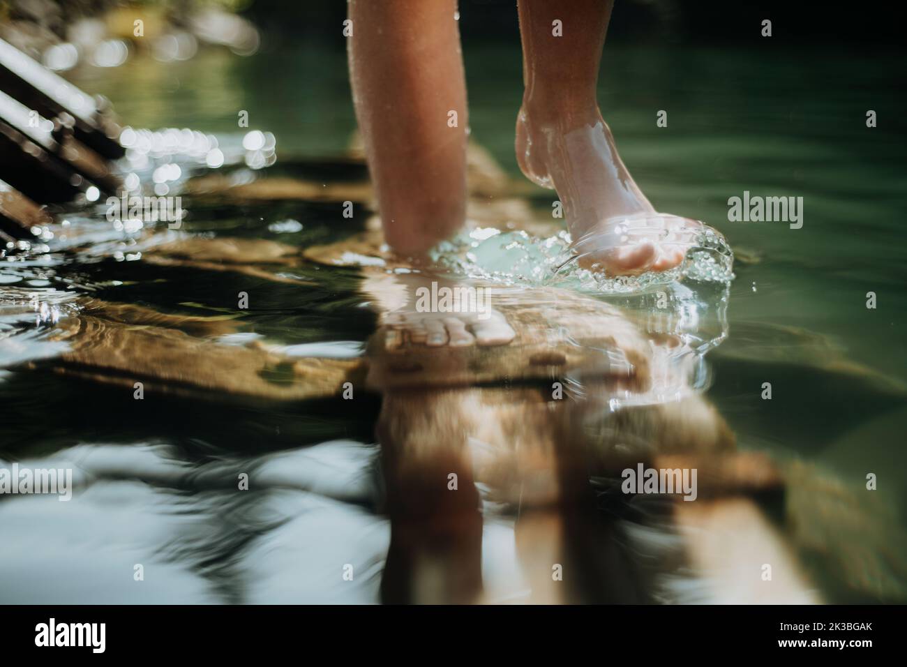 Close-up of barefoot legs walking in lake. Concept of healthy feet. Stock Photo