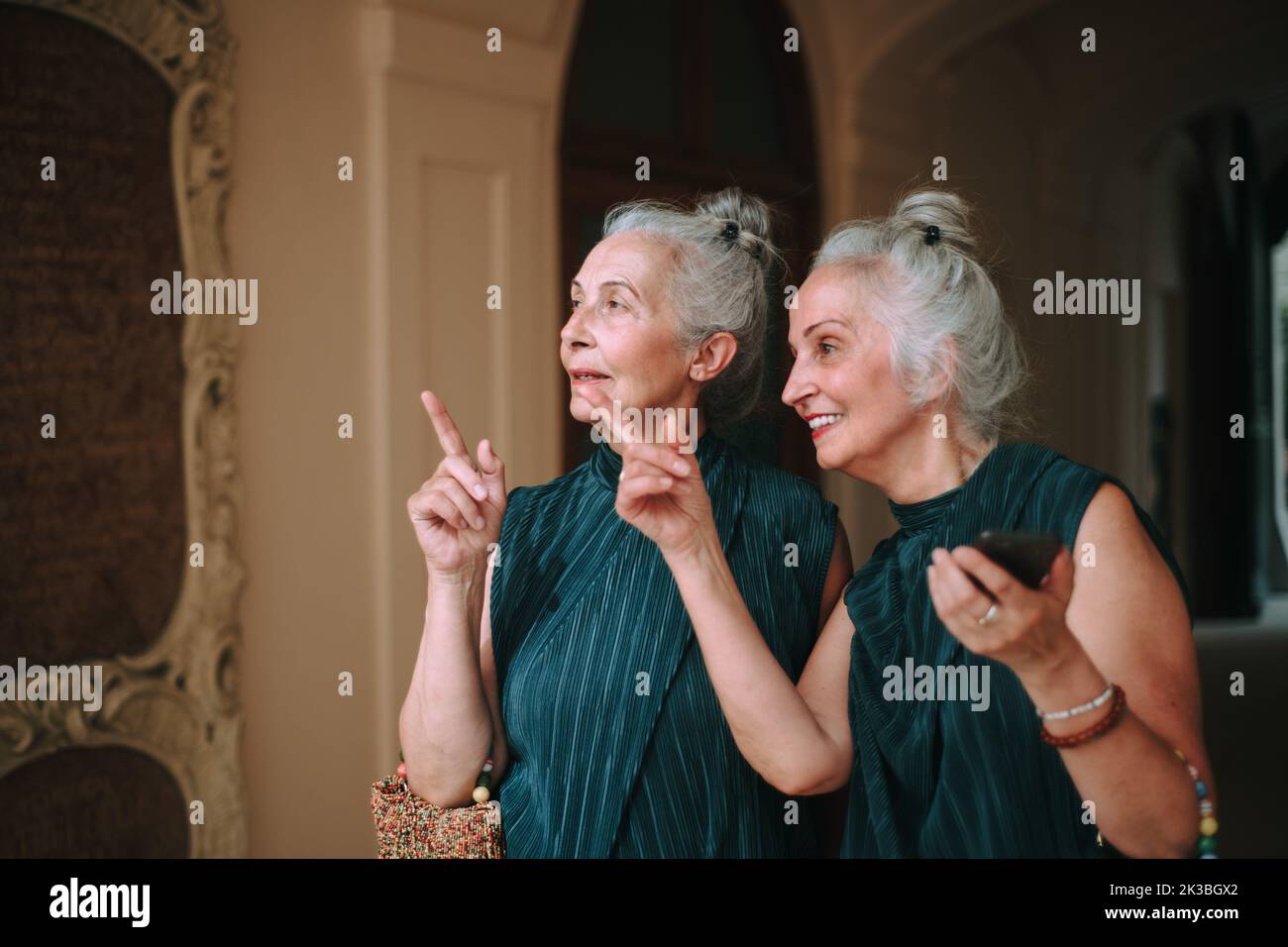 Senior women twins walking in city and admiring architecture. Stock Photo