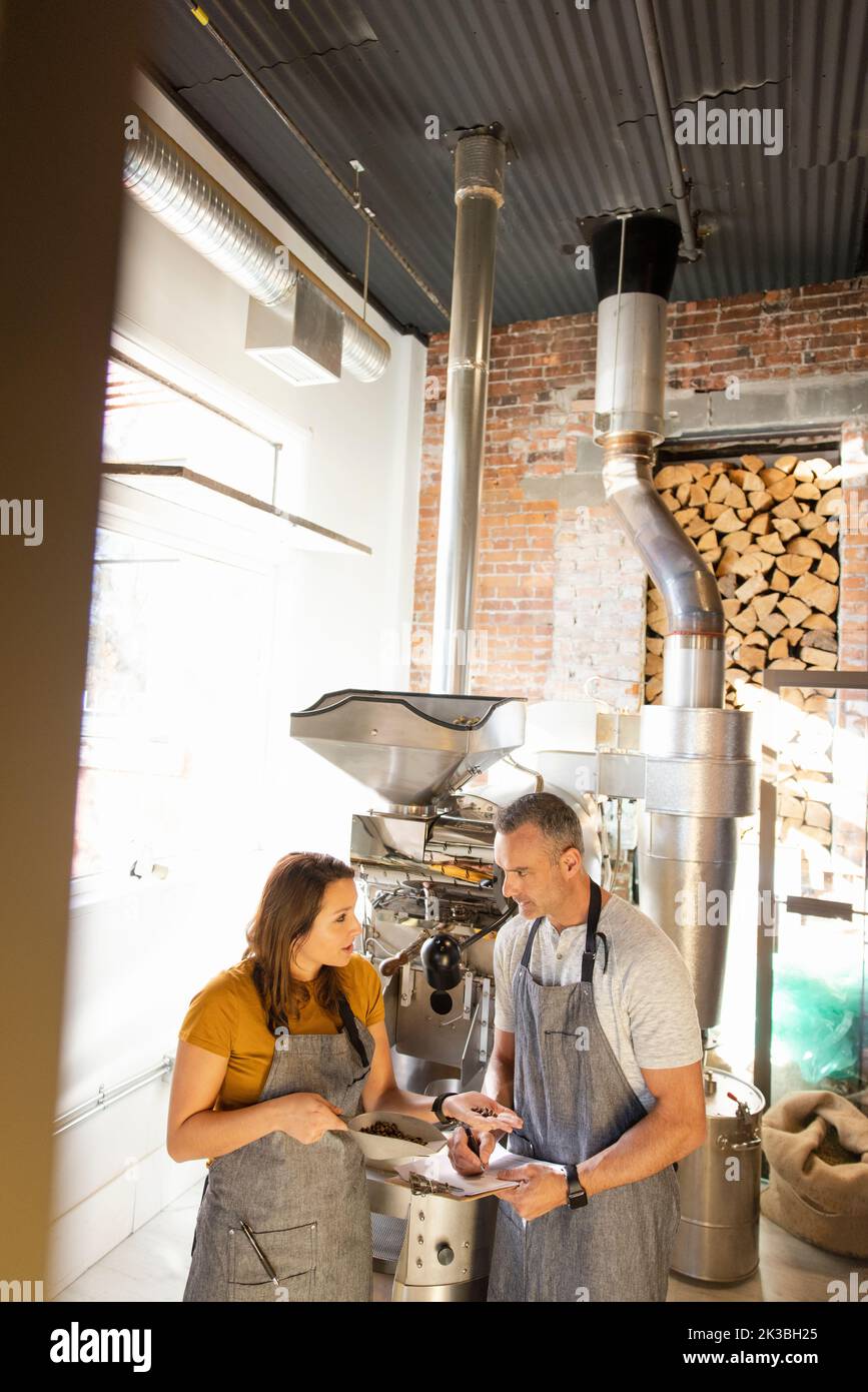 Business owners inspecting coffee beans at coffee roaster Stock Photo
