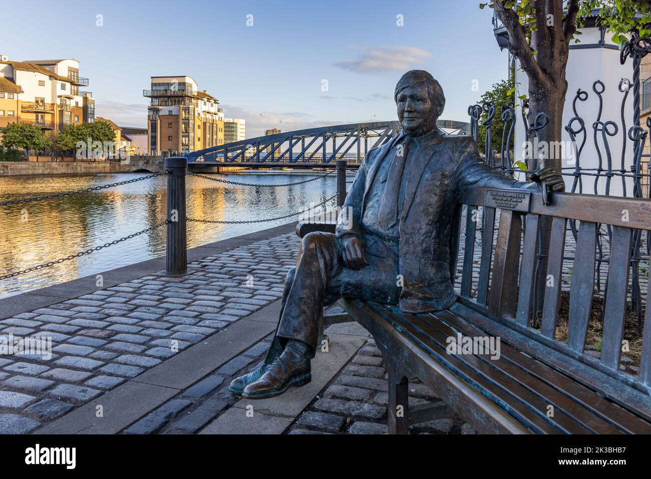 Life-size bronze statue of Sandy Irvine Robertson OBE (1942-1999) by Lucy Poett, sitting on a bench at The Shore, Leith, Edinburgh, Scotland. Stock Photo