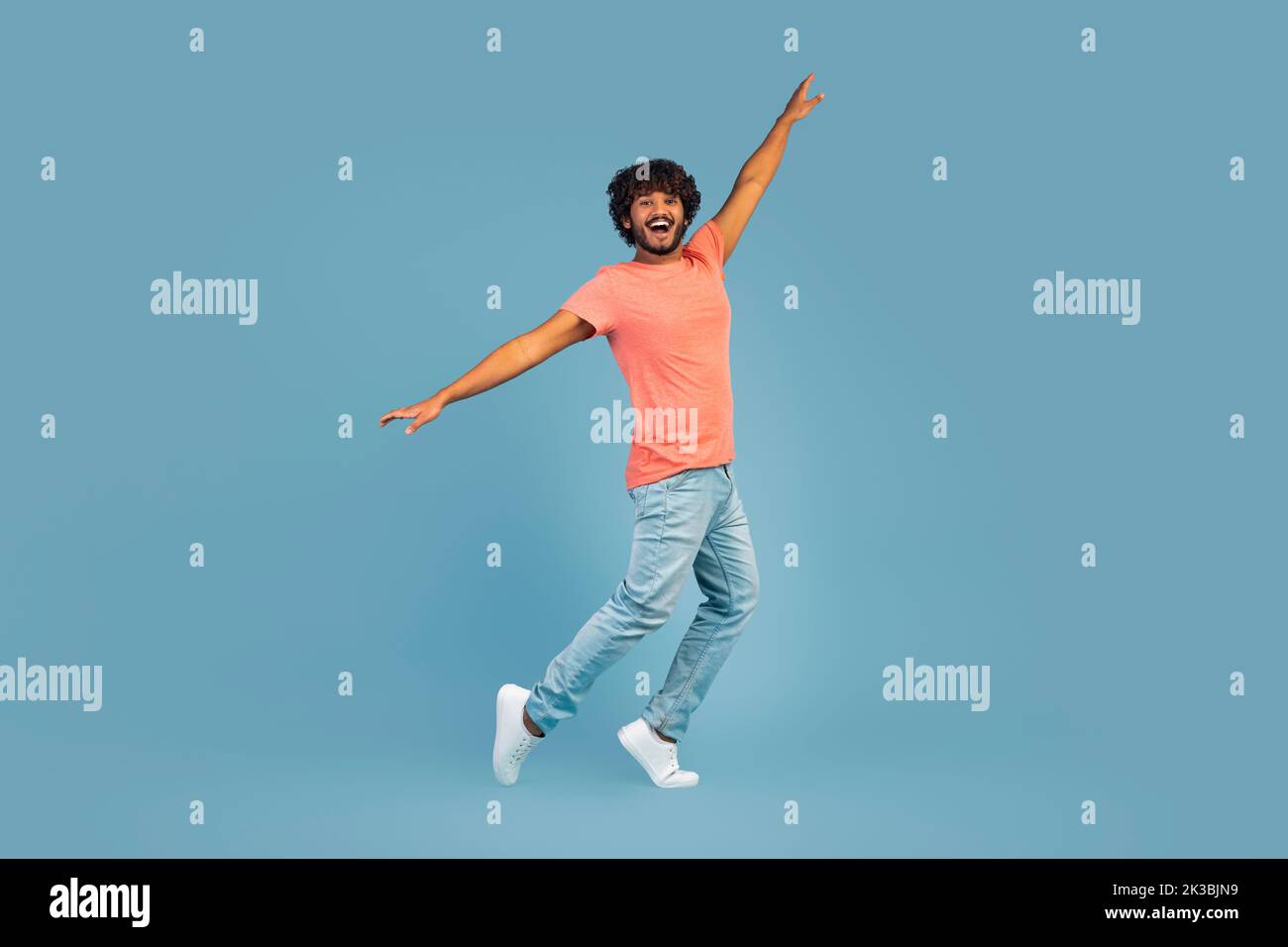 Positive hindu guy fooling over blue studio background Stock Photo