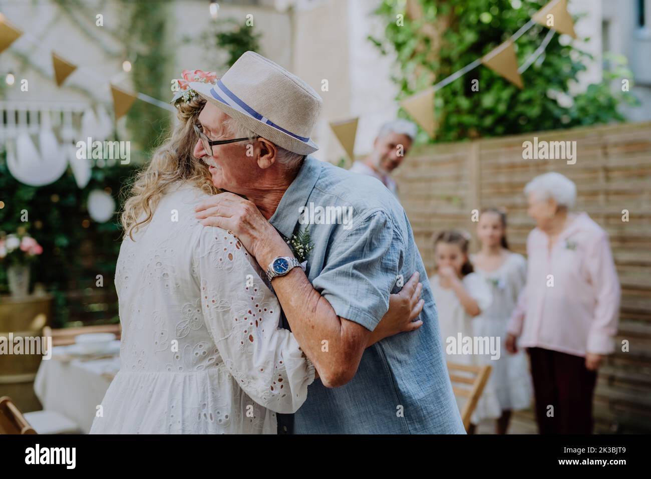 Mature bride receiving congratulations at wedding reception outside in the backyard. Stock Photo
