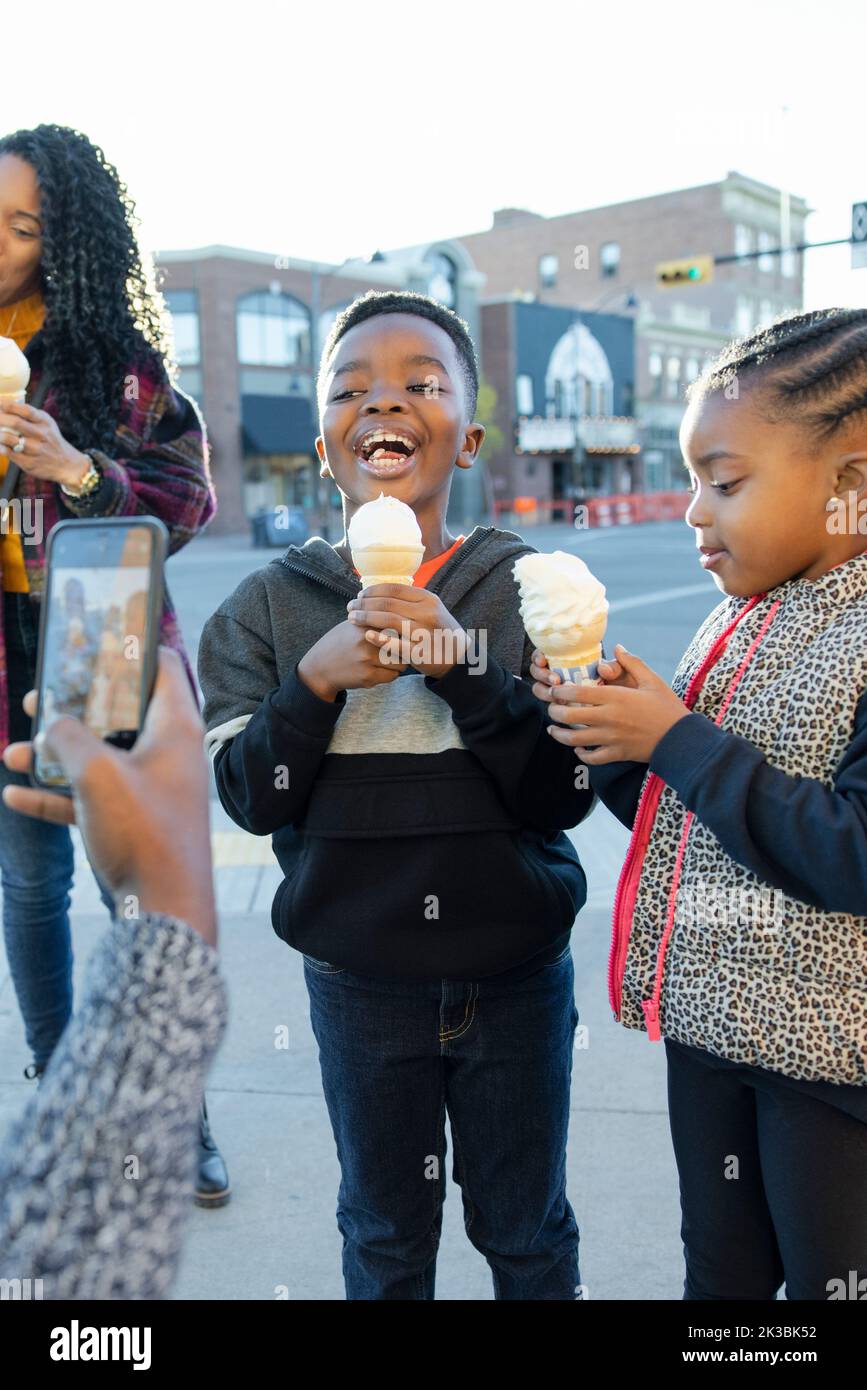 Cute kids eating ice cream cones on city corner Stock Photo Alamy