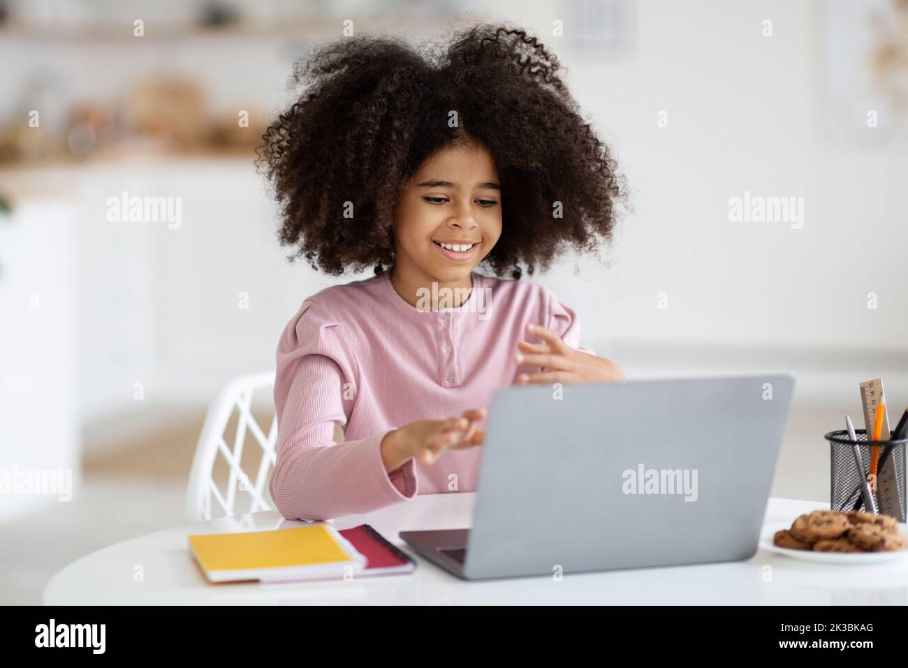 Cute african american school girl using laptop at home Stock Photo - Alamy