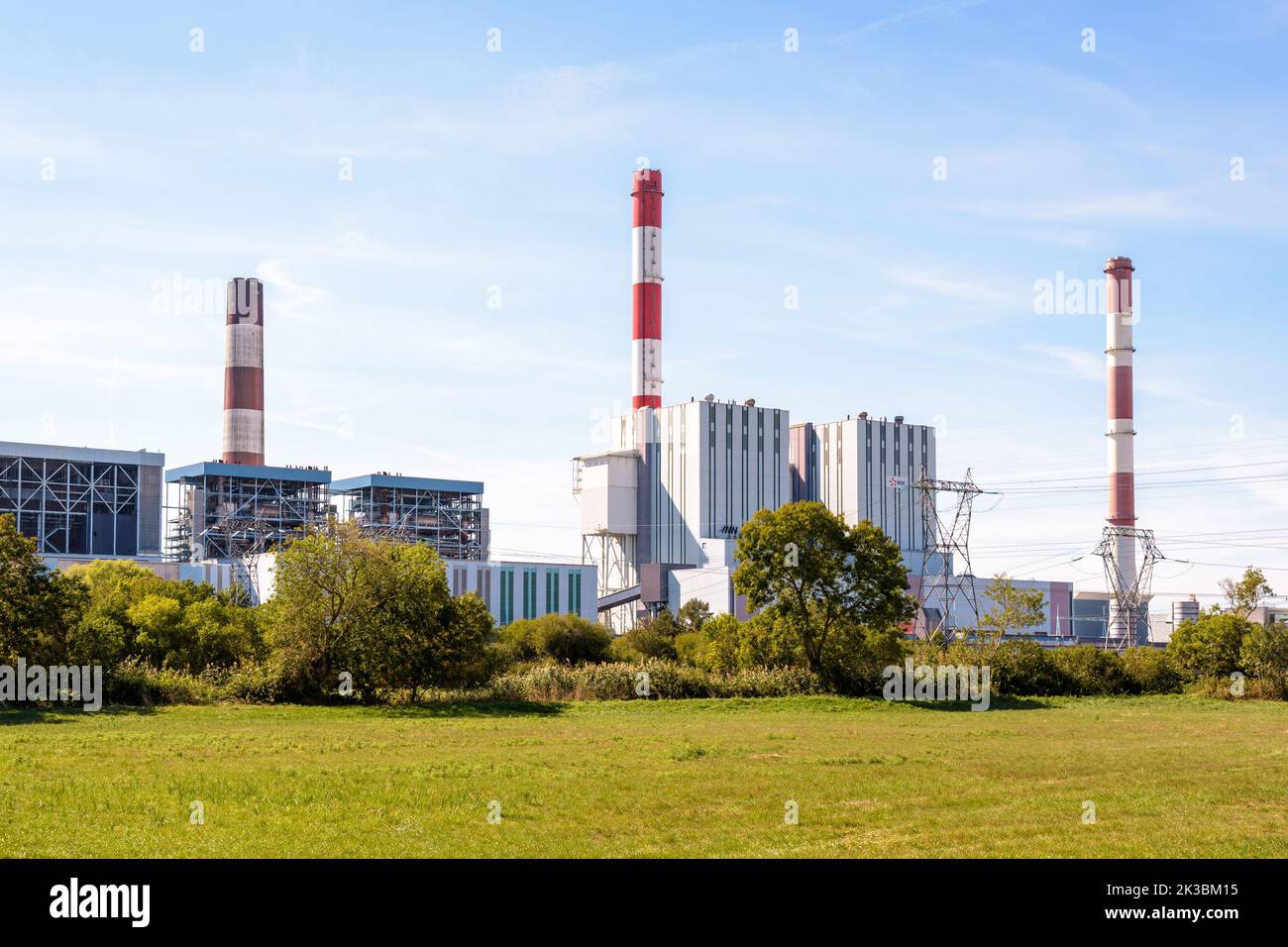 General view of the EDF coal-fired power station of Cordemais, France, with three red and white smokestacks, seen from the surrounding meadows. Stock Photo
