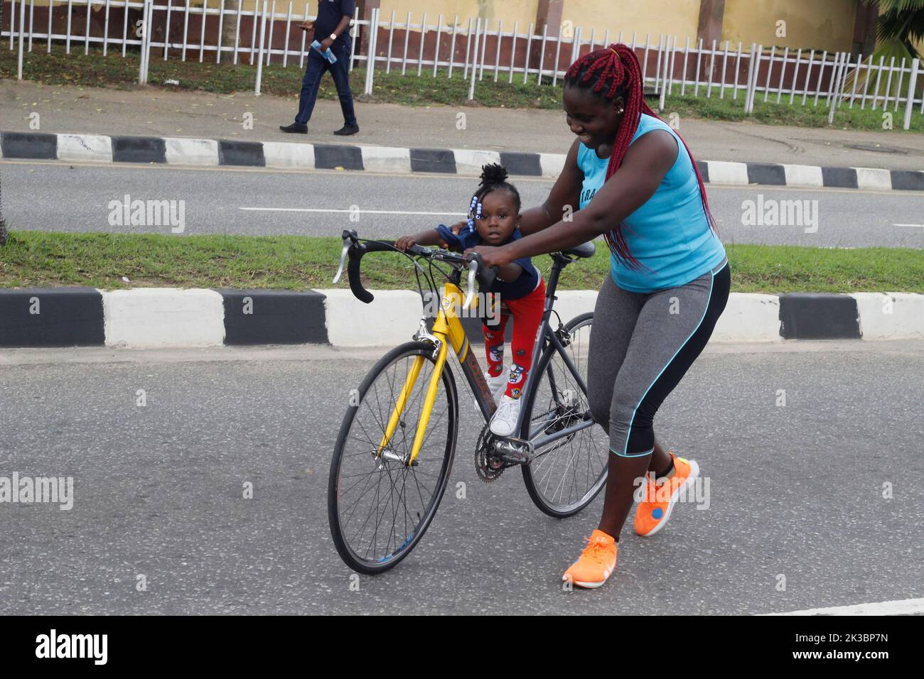 Lagos, Nigeria. 25th Sep, 2022. A woman carries a little girl on bicycle in Alausa as Lagos State Government celebrates 2022 World Car Free Day at Alausa, Ikeja, Lagos, Nigeria on Sunday, September 25 2022. The state government said it has included bicycle parking lot in some of its road infrastructure in order to encourage non-motorized transport plan and enhance citizens' fitness. Credit: Adekunle Ajayi/Alamy Live News Stock Photo