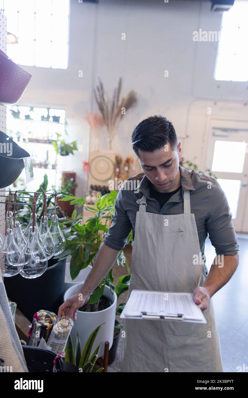 Plant shop owner with clipboard checking inventory Stock Photo
