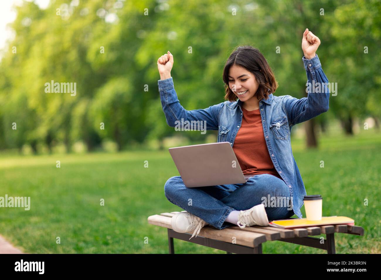 Beautiful Middle Eastern Female Student Celebrating Success With Laptop Outdoors Stock Photo