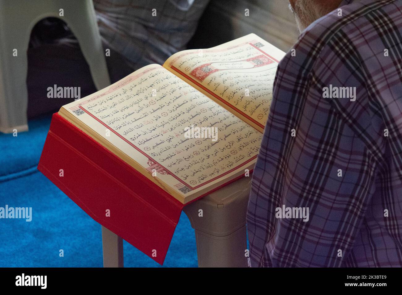 Man reading Quran in mosque, Islam and religion concept, open Quran page, Islamic footage, faith and belief, holy book, worship and pray idea Stock Photo