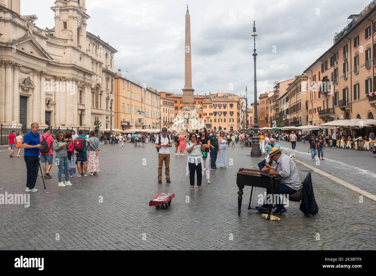 Rome, Italy - September 25, 2022 -  Tourists enjoying sightseeing in Piazza Navona next to a Baroque fountaint Stock Photo
