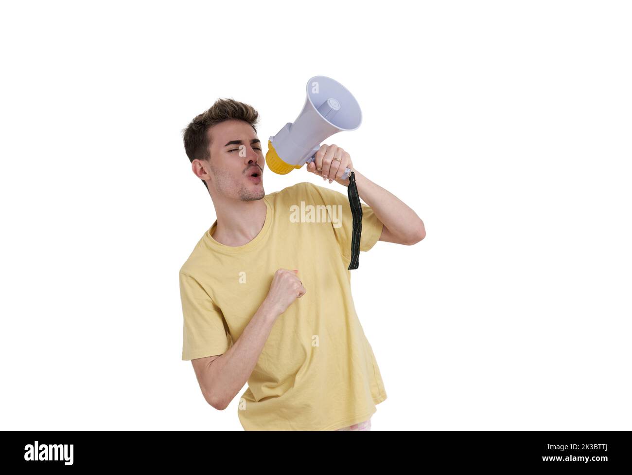 Young caucasian man shouting through megaphone, isolated. Stock Photo