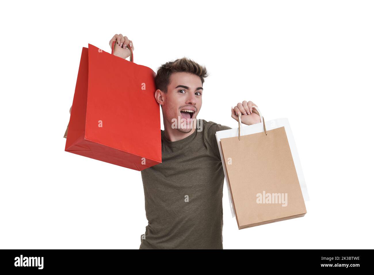 Young caucasian man super happy holding shopping bags, isolated. Stock Photo