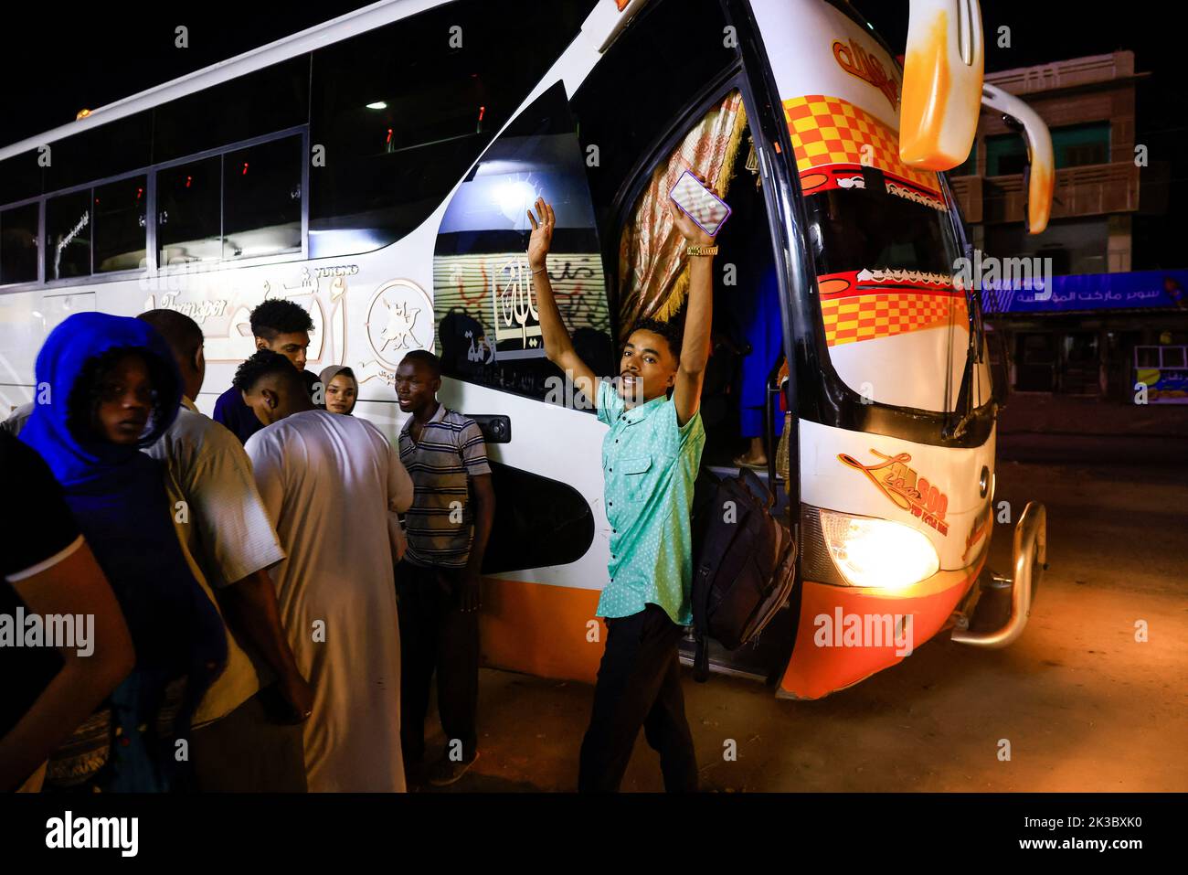 Mohamed waves to his friends before the bus leaves for Egypt in Khartoum, Sudan September 24, 2022. REUTERS/Mohamed Nureldin Abdallah Stock Photo
