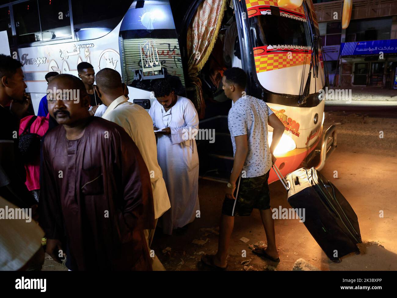 People gather to check their names before riding on the bus leaving for Egypt in Khartoum, Sudan September 24, 2022. REUTERS/Mohamed Nureldin Abdallah Stock Photo