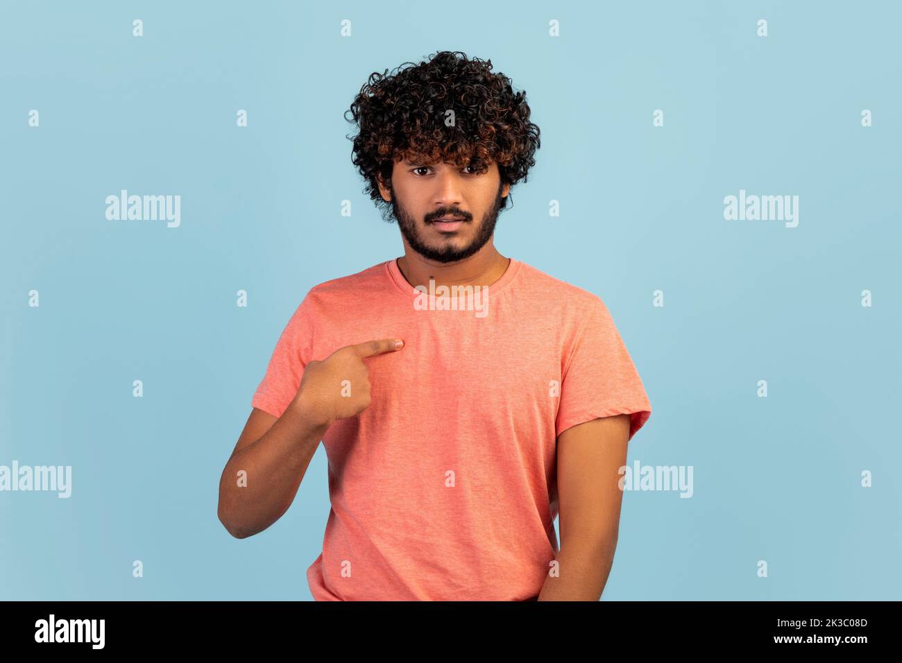 Questioned handsome indian man looking surprised pointing himself Stock Photo