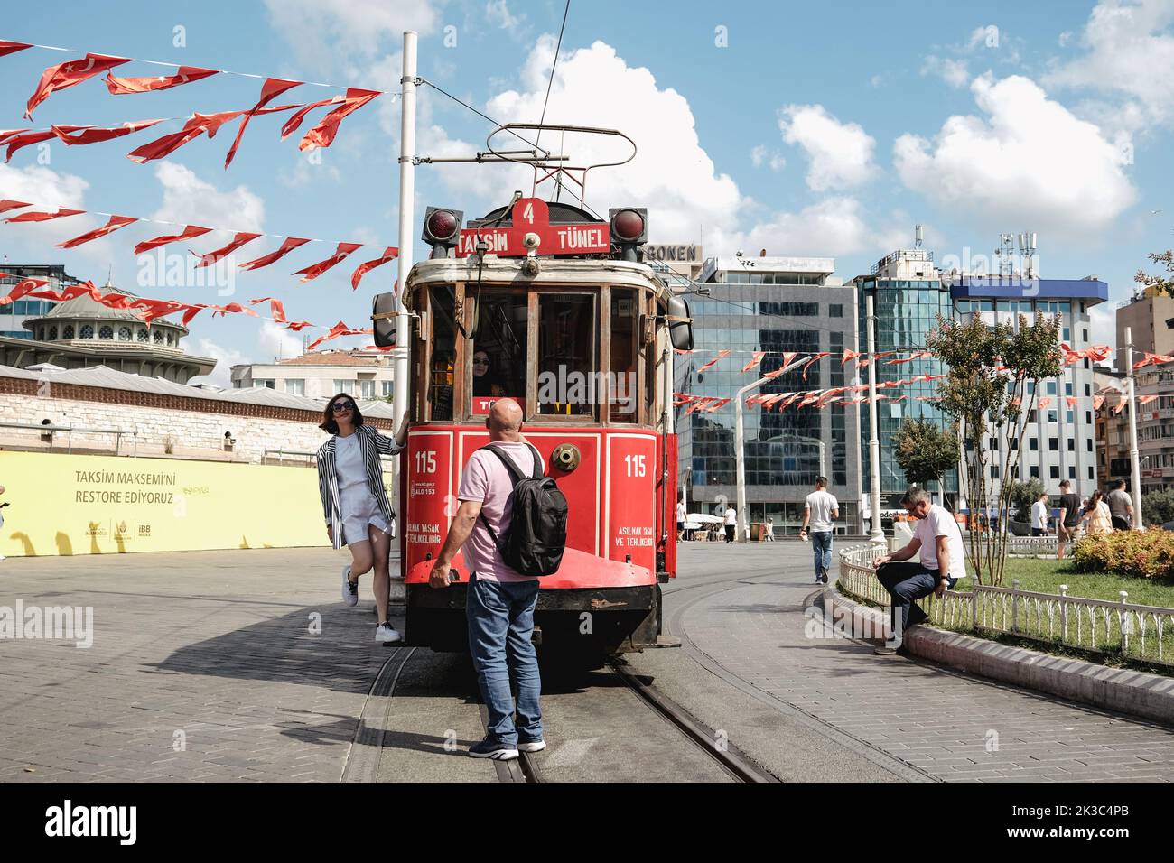 People taking photos in retro Taksim tram, red famous train in Istanbul, travel and trip concept, sunny summer day, cityscape in Taksim square Stock Photo
