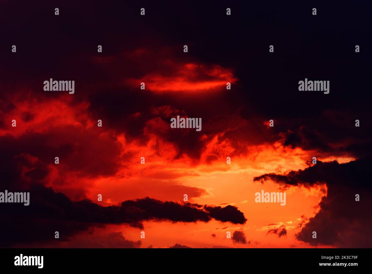 Dark orange sunset sky with heavy stormy clouds in summer Stock Photo
