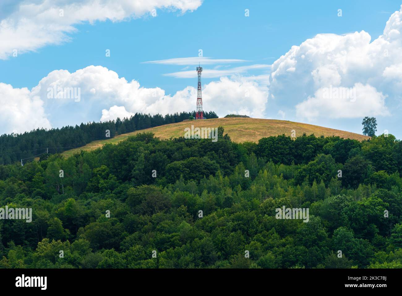Telecommunication tower on top of the hill on sunny summer day Stock Photo