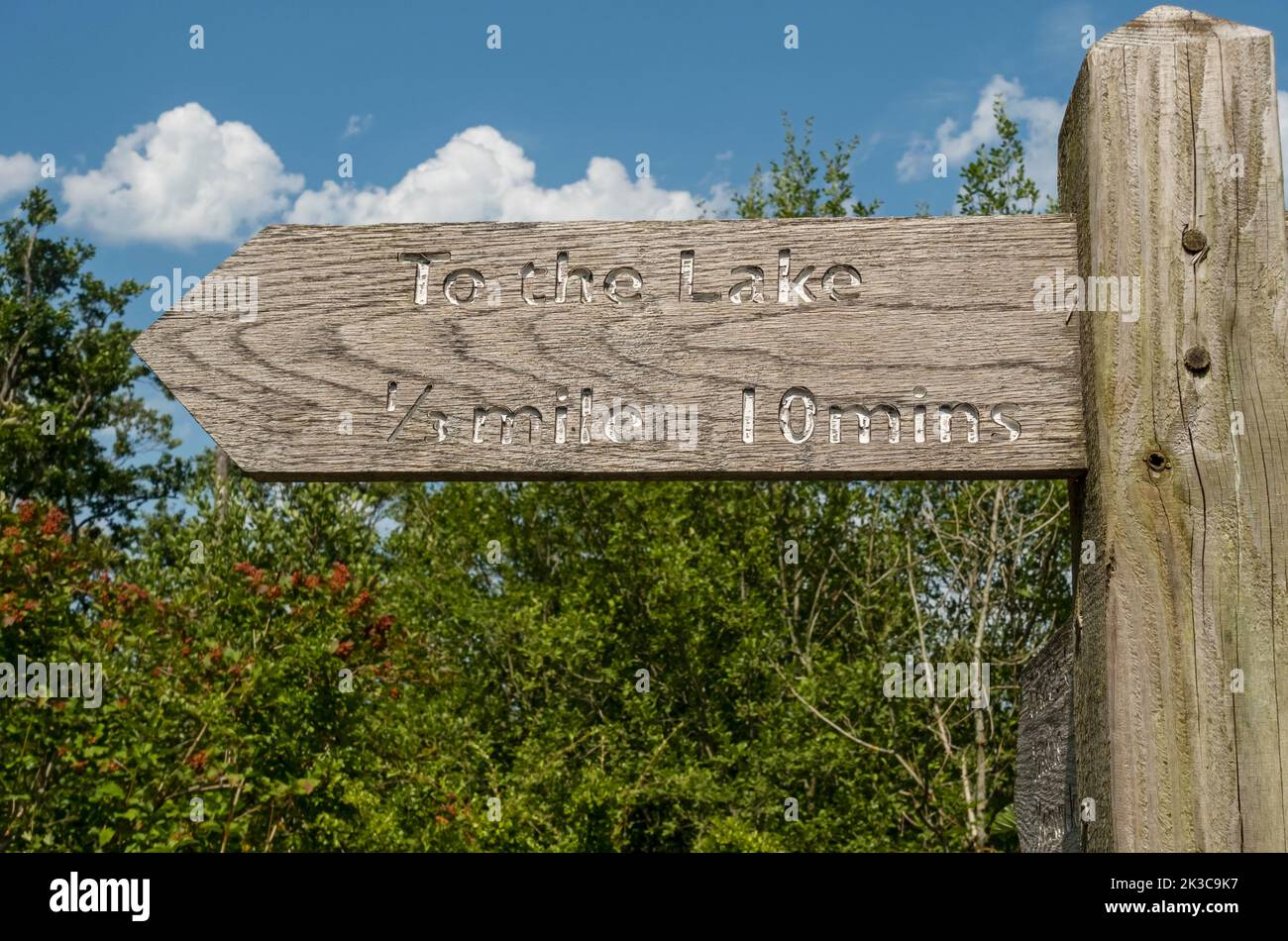 Close up of wooden public direction footpath sign to the lake near Derwentwater  and Keswick in summer Lake District National Park Cumbria England UK Stock Photo